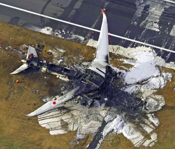 An aerial view shows burnt Japan Airlines' (JAL) Airbus A350 plane after a collision with a Japan Coast Guard aircraft at Haneda International Airport in Tokyo,
